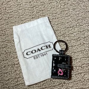 black coach keychain or purse charm with a pink heart
